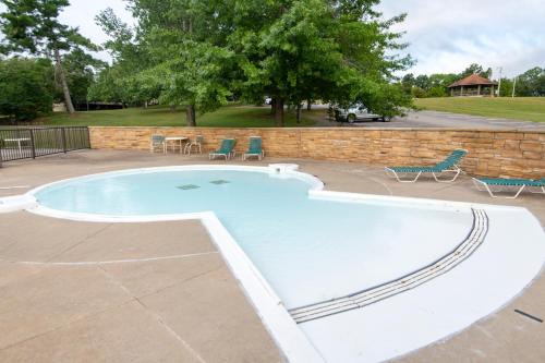 a large swimming pool with chairs and a brick wall at Rough River Dam State Resort Park in Fentress McMahan