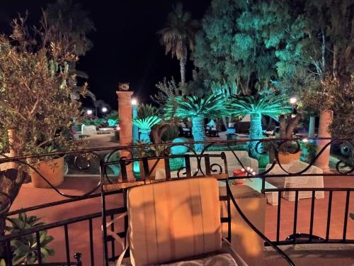 a balcony with a table and chairs at night at Residenza Villa Spagnola in Parghelia