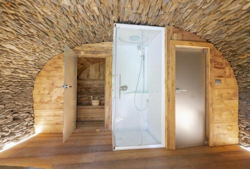 een badkamer met een douche en een glazen deur bij Amelu' in Ostana