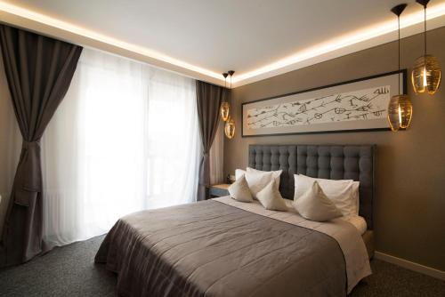 a bedroom with a large bed with white pillows at Bartolomeo in Dnipro