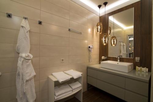 Baño blanco con lavabo y espejo en Bartolomeo, en Dnipro
