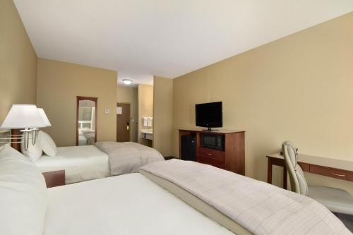 Ένα ή περισσότερα κρεβάτια σε δωμάτιο στο Days Inn & Suites by Wyndham Brandon