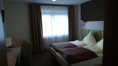 a hotel room with a bed and a window at Rhönblick Landhotel - Restaurant - Countrypub in Petersberg