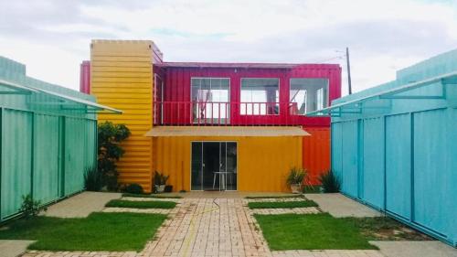 ein farbenfrohes Haus mit Balkon darüber in der Unterkunft Mandala House Container in Chapada dos Guimarães