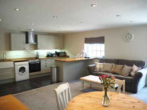 una cucina e un soggiorno con divano e tavolo di Harepath Farm Cottages 1 a Exeter