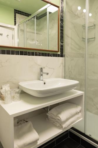 a bathroom with a sink and a mirror and towels at Grand Hotel Tamerici & Principe in Montecatini Terme