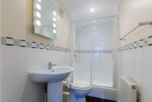 a bathroom with a sink and a toilet and a shower at Beach Retreat Broadstairs in Broadstairs