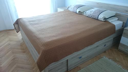 ein großes Bett in einem Schlafzimmer mit Holzboden in der Unterkunft Apartman Marin in Šilo