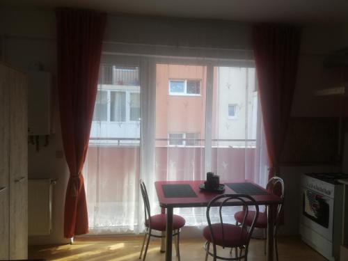 een tafel en stoelen voor een raam bij Apartament Maria in Floreşti