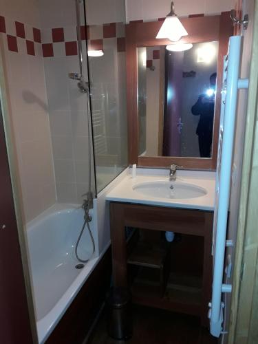 une salle de bain avec un lavabo, une baignoire et un miroir dans l'établissement Les temples du soleil, à Val Thorens