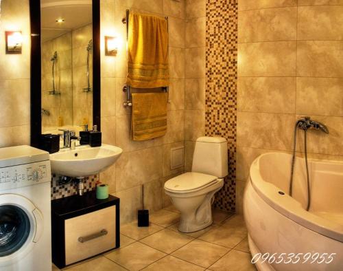 La salle de bains est pourvue d'un lavabo, de toilettes et d'un lave-linge. dans l'établissement Квартира в центре с видом на Южный Буг, à Vinnytsia