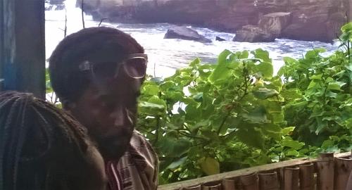 a man wearing sunglasses standing next to some plants at Rising Phoenix in Accra