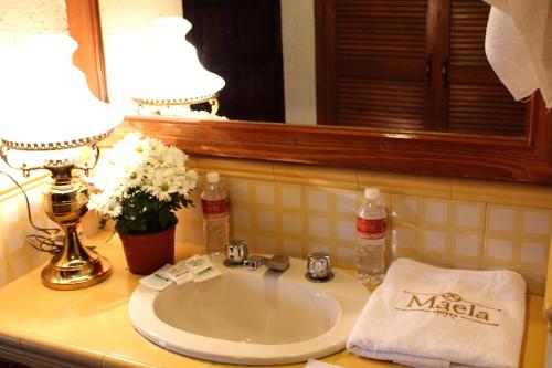 lavabo con 2 lámparas y espejo en Hotel Maela, en Oaxaca City