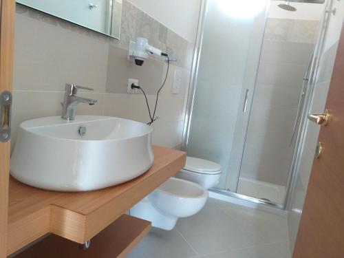 a bathroom with a sink and a shower and a toilet at appartamenti baia di peschici in Peschici