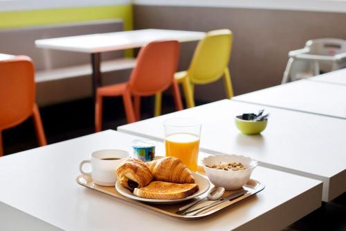 a breakfast of croissants and coffee and orange juice on a table at ibis budget Huerta De Murcia in Murcia