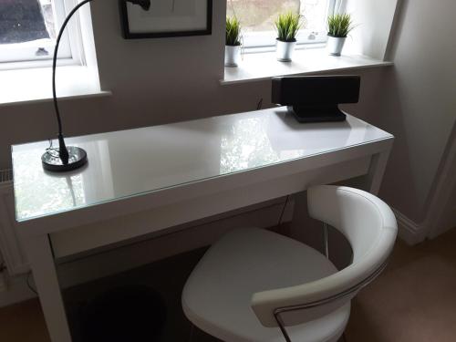 a white desk with a chair and a lamp at Fabulous Double ensuite room in Sefton Park Lark Lane in Liverpool