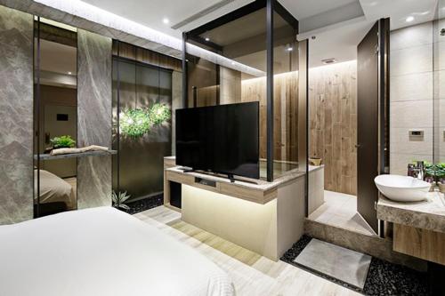 a hotel room with a tv and a sink at JBG Hotspring Resort Hotel in Taipei