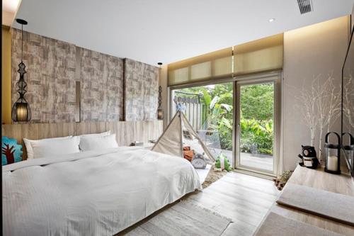 a bedroom with a white bed and a large window at JBG Hotspring Resort Hotel in Taipei