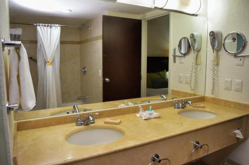 baño con 2 lavabos y espejo grande en Hotel Villa Florida Veracruz, en Veracruz
