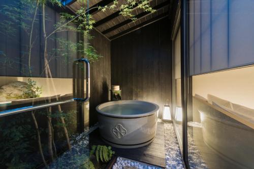 a bath tub sitting in the corner of a bathroom at Kiraku Kyoto Honmachi in Kyoto