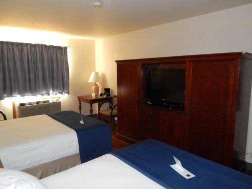 Americas Best Value Inn Sault Ste. Marie في سولت سانت ماري: غرفة فندقية بسريرين وتلفزيون بشاشة مسطحة