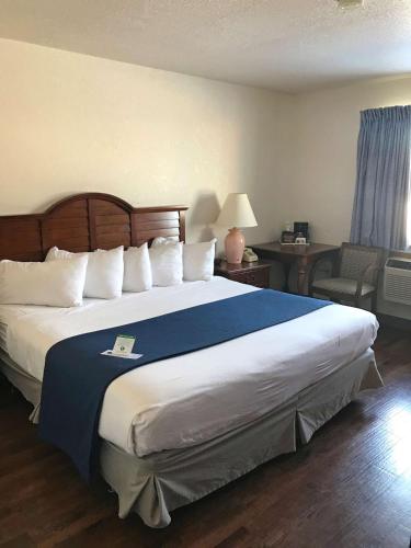 um quarto com uma cama grande e um cobertor azul em Americas Best Value Inn Sault Ste. Marie em Sault Ste. Marie
