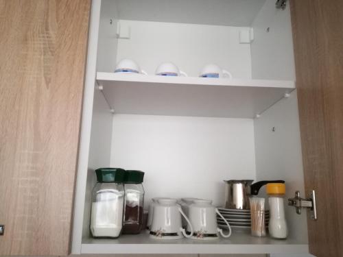 a cupboard filled with lots of kitchen utensils at Enjoy Apartments Karamach in Ohrid