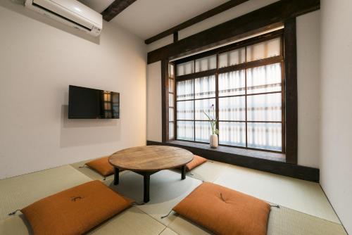 a room with a table and chairs and a window at Kiraku Kyoto Honmachi in Kyoto