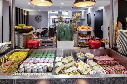 a buffet line with many different types of food at Mercure Le Mans Centre in Le Mans