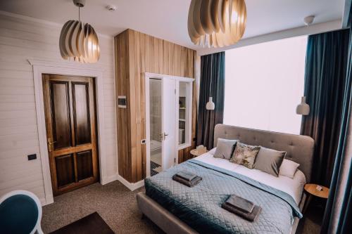 a bedroom with a bed and a large window at Bahnhofs hotel in Alūksne