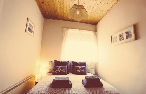 a bedroom with a bed with two pillows on it at Little Haven in Seahouses
