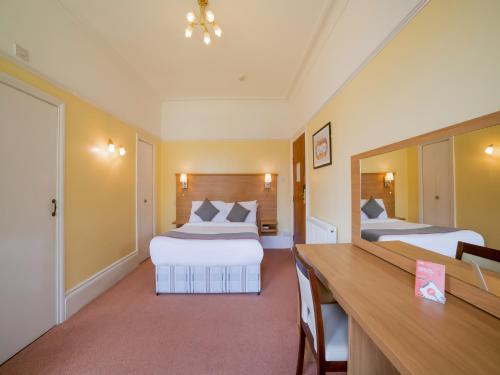 Кровать или кровати в номере OYO Eagle House Hotel, St Leonards Hastings