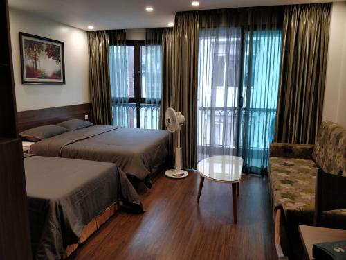 een hotelkamer met 2 bedden en een bank bij Zody House in Hanoi