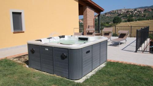 a hot tub sitting on the side of a house at Al Ginepro in Montecchio