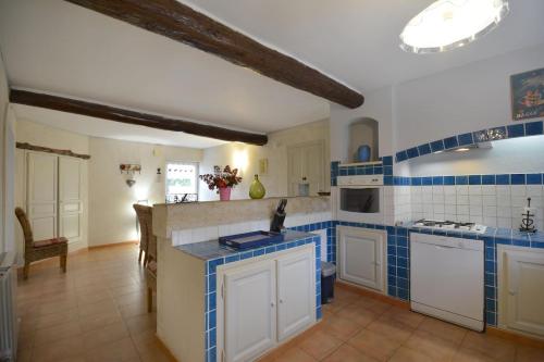 uma cozinha com azulejos azuis e brancos nas paredes em Gîte Soleïado em Eyragues