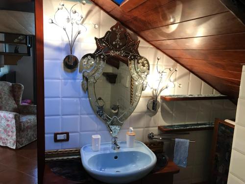 La salle de bains est pourvue d'un lavabo et d'un miroir mural. dans l'établissement Maison Claudià al Lido di Venezia, sur le Lido de Venise