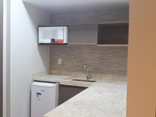 a kitchen with a sink and a refrigerator at Rio Quente Flat Veredas Apto - 231 in Rio Quente