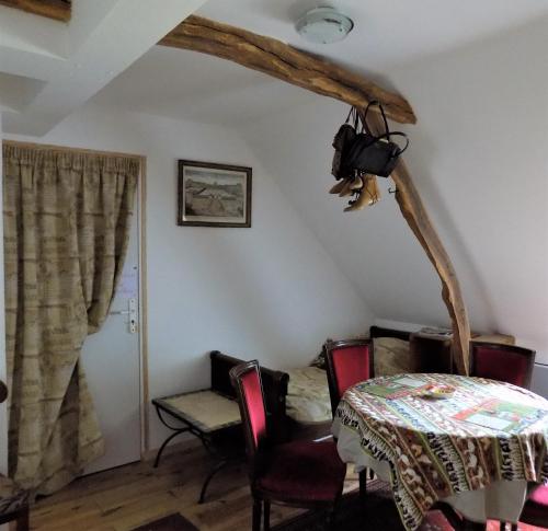 une salle à manger avec une table et des chaises dans une pièce dans l'établissement Les chambres des Demoiselles, à Beauval