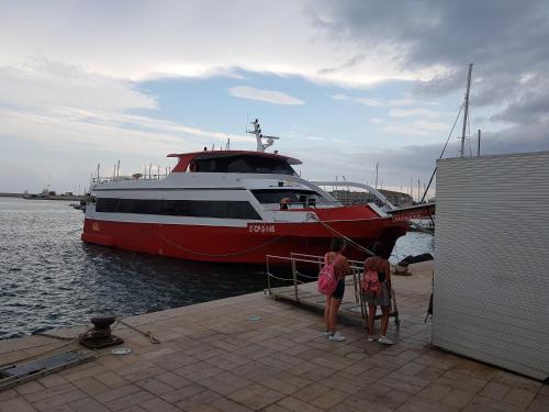 a red and white boat is docked at a dock at Casa Horadada in Algorfa