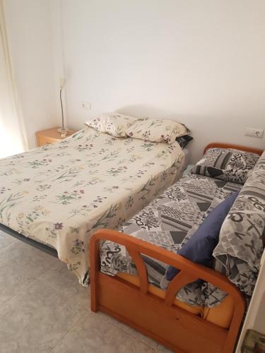 een slaapkamer met een bed en 2 aparte bedden bij Casa Horadada in Algorfa