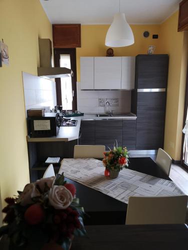 a kitchen with a table and chairs and a kitchen with white cabinets at La Casa Dei Nonni in Bussoleno