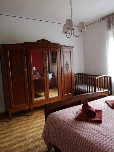 a bedroom with a bed and a wooden cabinet at La Casa Dei Nonni in Bussoleno