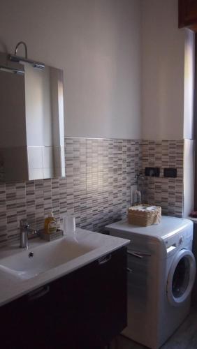 a bathroom with a sink and a washing machine at La Casa Dei Nonni in Bussoleno