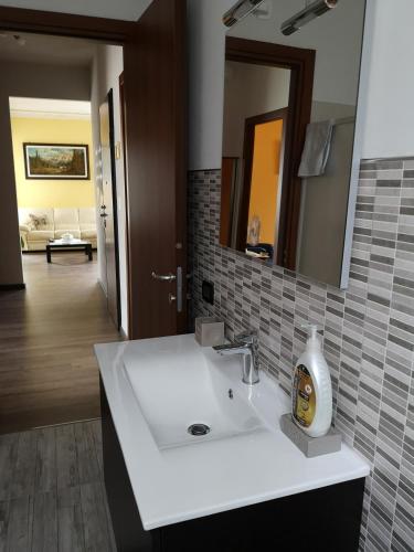 a bathroom with a white sink and a mirror at La Casa Dei Nonni in Bussoleno