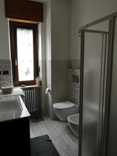 a bathroom with a sink and a toilet and a window at La Casa Dei Nonni in Bussoleno