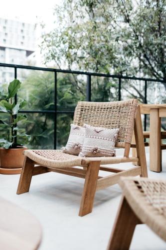a rattan chair with pillows on a balcony at Casa Pancha in Mexico City