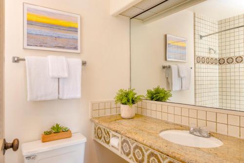 a bathroom with a sink and a mirror at Clocktower Inn Ventura in Ventura