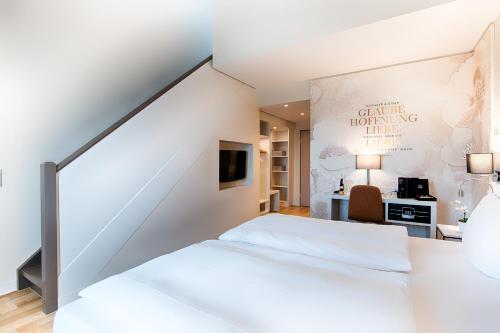 a bedroom with a white bed and a desk at Welcome Hotel Bad Arolsen in Bad Arolsen