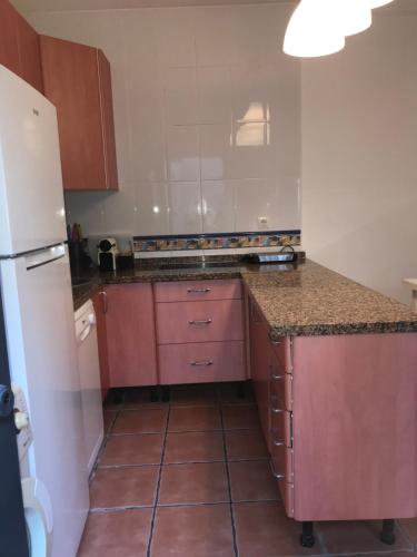 una cucina con armadietti rosa e frigorifero bianco di MARIÑIGUEZ APARTAMENT. a Jerez de la Frontera