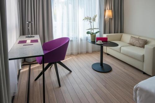 a living room filled with furniture and a table at Mercure Ajaccio in Ajaccio